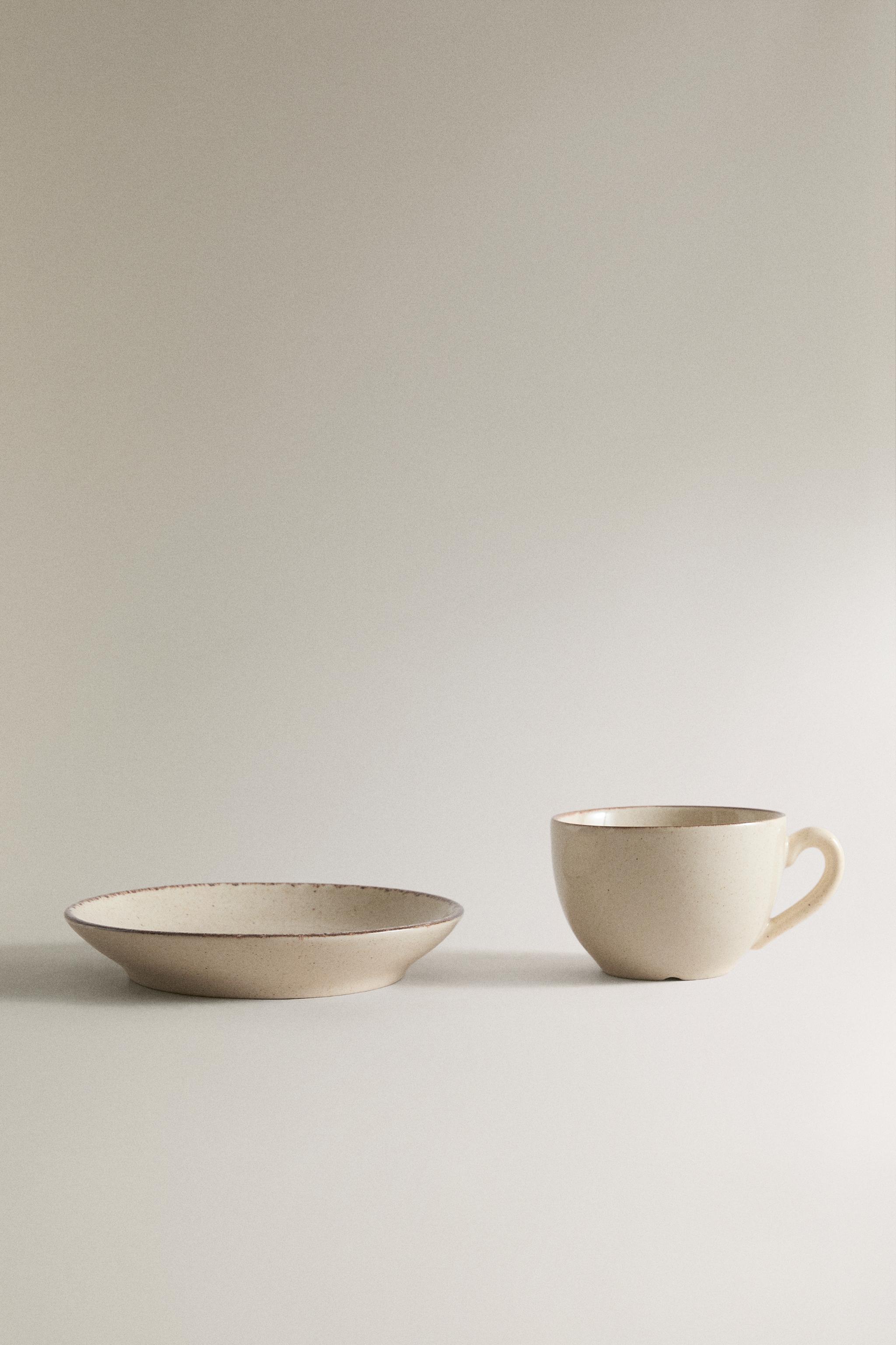 STONEWARE TEACUP AND SAUCER WITH DISTRESSED RIM